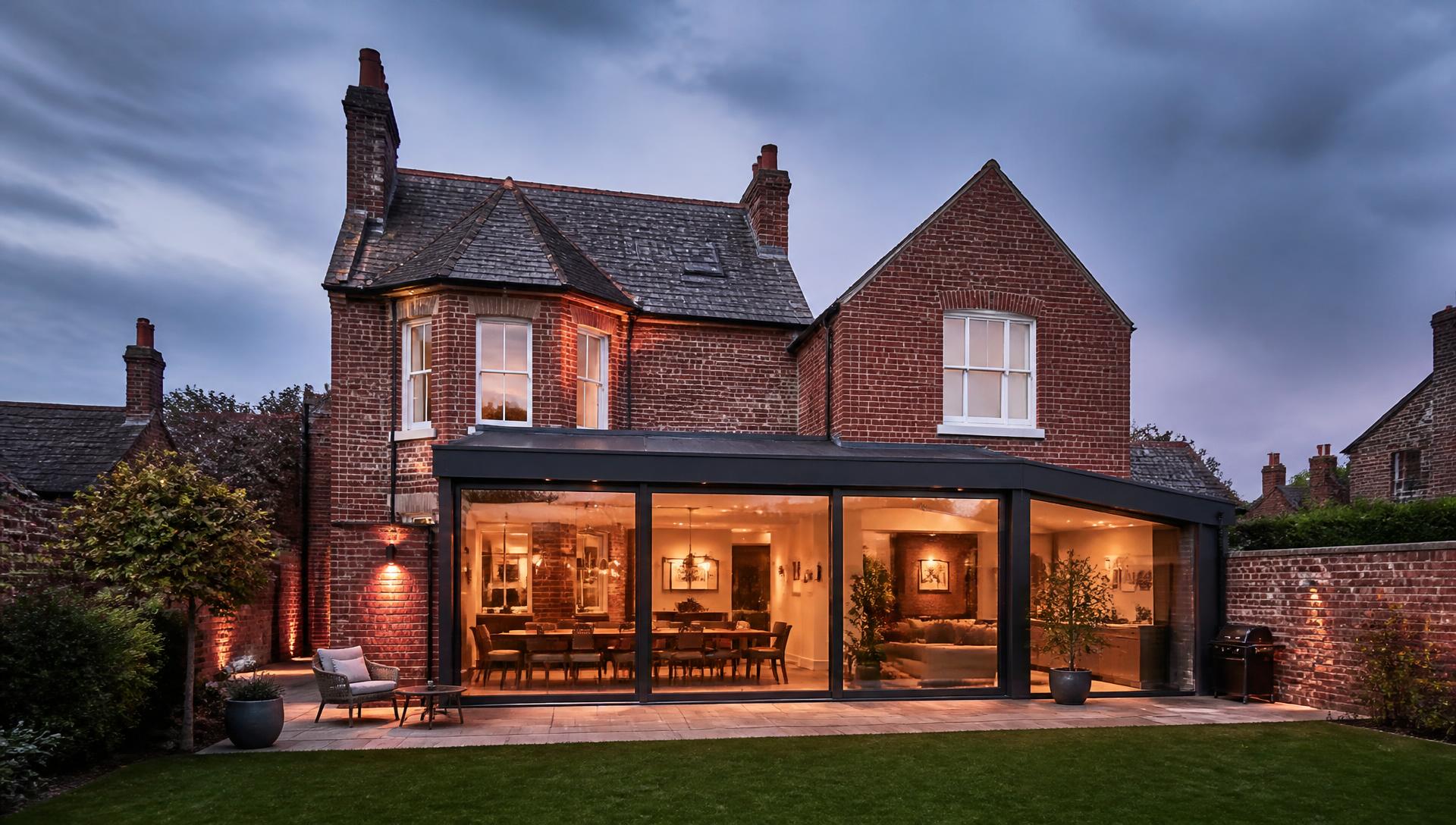 Red brick house with a modern glazed rear extension built by Trackrecord Construction